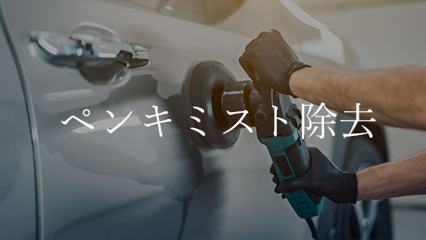 Technician wearing gloves uses a power polisher on a car door to remove paint overspray in auto body work.