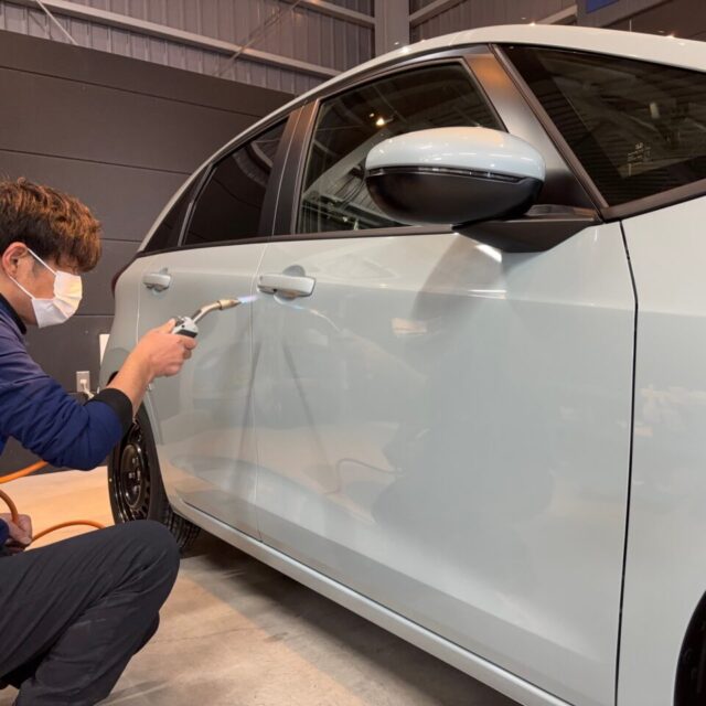 徳島県のカーコーティング専門店「SOUP」で、新車Honda Fit（ホンダ フィット）にセラミックコーティング「SystemX Pro」を施工中の様子。施工スタッフがガスプライマーを使い、コーティングの密着性を高める作業を丁寧に行っている。