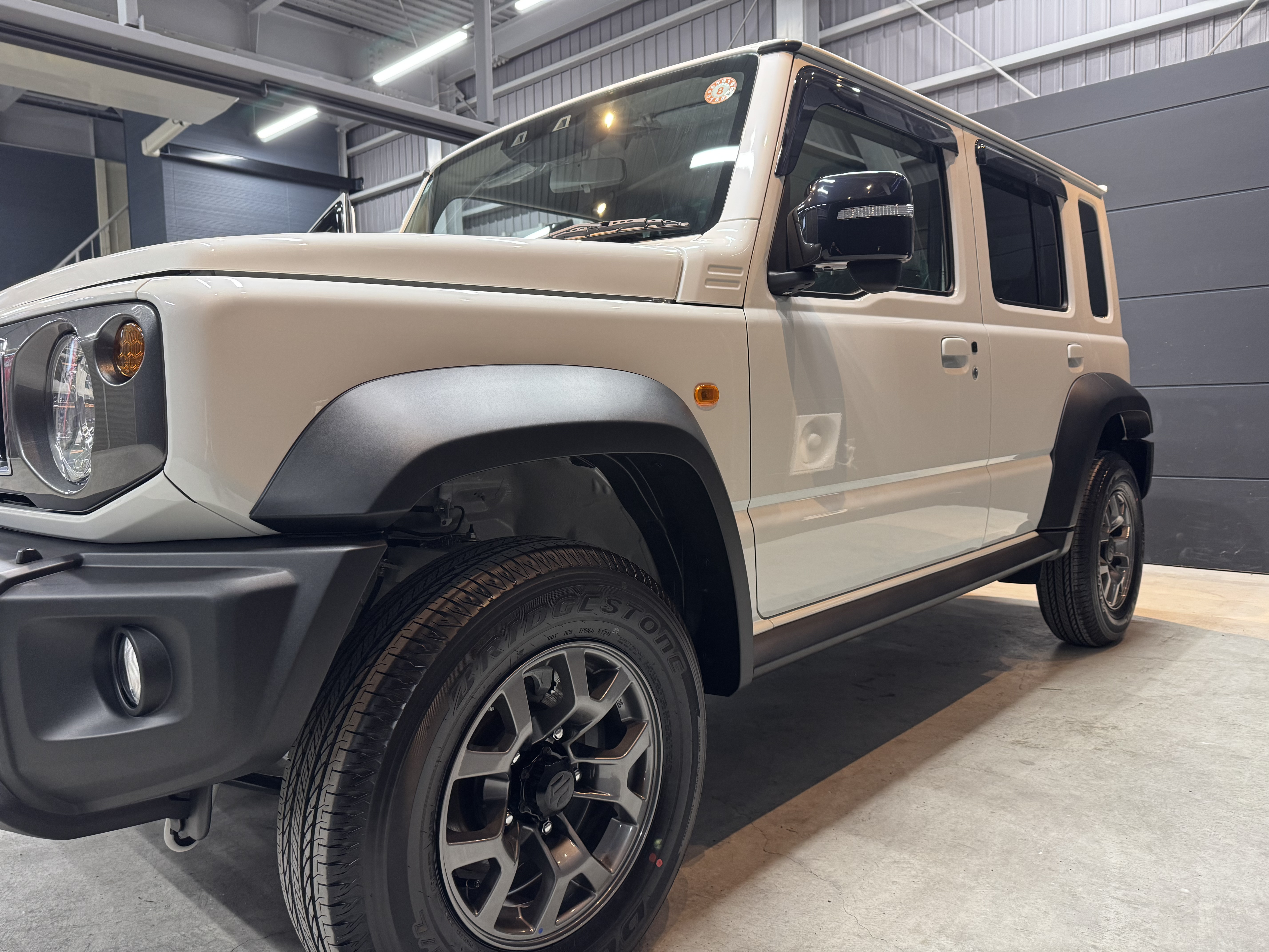 アウトドアシーンに溶け込むスズキ・ジムニー ノマド。無骨なスタイルとタフな足回りが映える一枚。SOUPのセラミックコーティングで自然の中でも存在感を放つ、特別な一台。