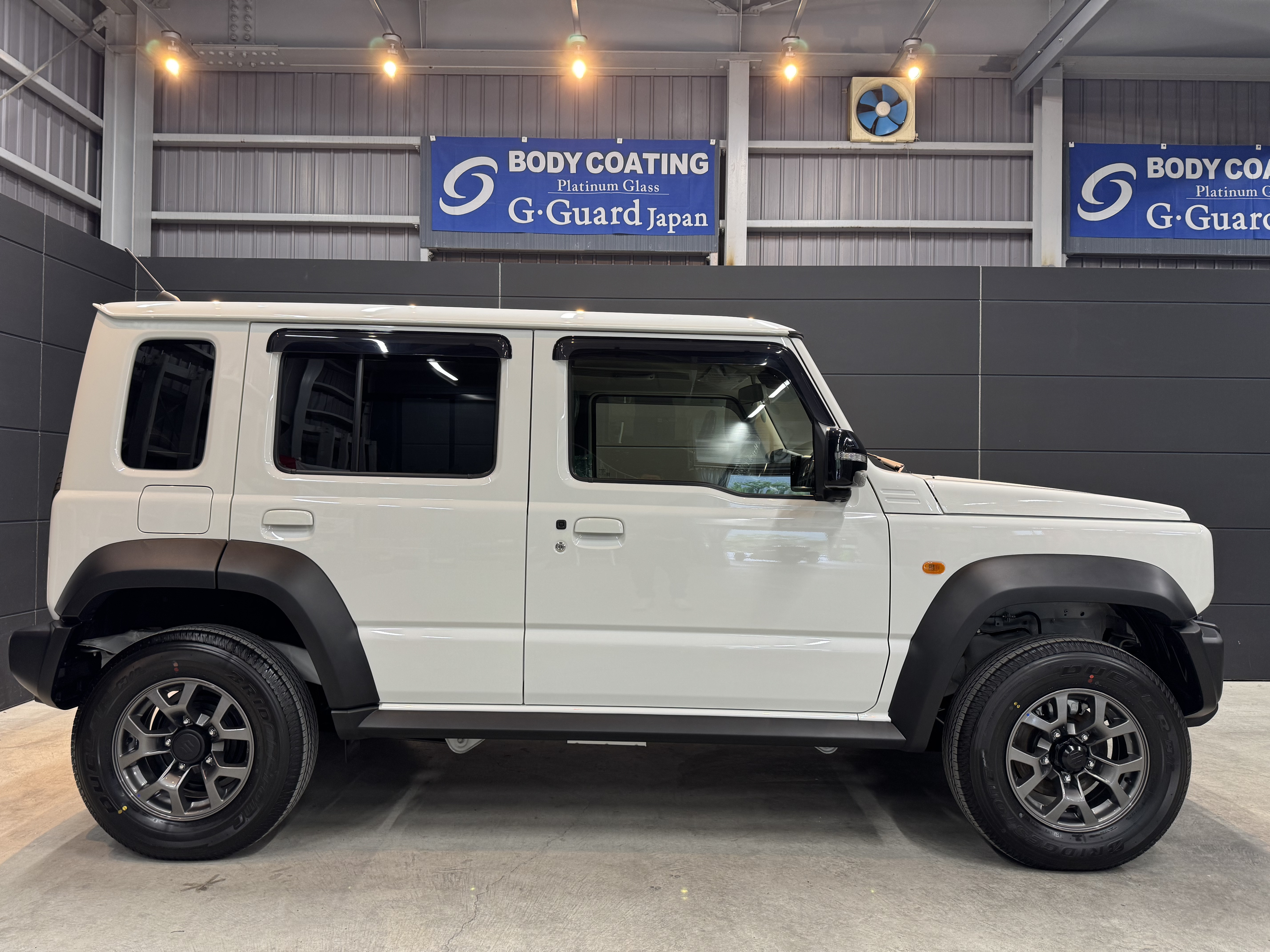 アウトドアシーンに溶け込むスズキ・ジムニー ノマド。無骨なスタイルとタフな足回りが映える一枚。SOUPのセラミックコーティングで自然の中でも存在感を放つ、特別な一台。