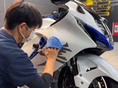 徳島県三好市のバイクコーティング専門店SOUPにて、スズキ 隼（EJ11A）にSystemX PROセラミックコーティングを施工中。 スプレーガンによる均一な塗布と、細部には手塗り施工を施すプロフェッショナルな作業風景。