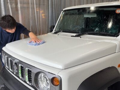 徳島県三好市のカーコーティング専門店SOUPにて、新車スズキ ジムニー（JC74W ノマド）にG.Guard 3層ガラスコーティングを施工中。 下地処理から細部洗浄、ボディ全体の洗浄までを丁寧に行う施工風景。美しい艶仕上げを目指した職人の手仕事。