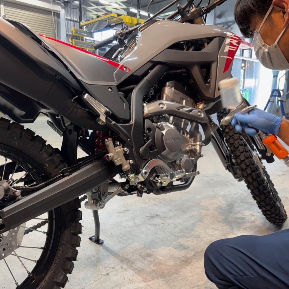 徳島県三好市のバイクコーティング専門店SOUPにて、ホンダ 新車 CRF250L（MD47）にSystemX PROセラミックコーティングを施工中。 細部パーツはスプレーガンで均一に塗布し、手塗りを施すことで、あらゆるパーツをムラなく保護する専門施工。