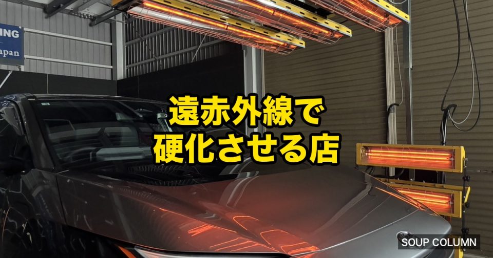 Car in a workshop bathed in orange infrared heaters with bold yellow Japanese text '遠赤外線で硬化させる店' overlaying the image