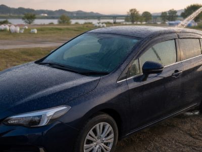 夜の花火会場近くで細かな灰が付いた濃色の車を翌朝水洗いする様子